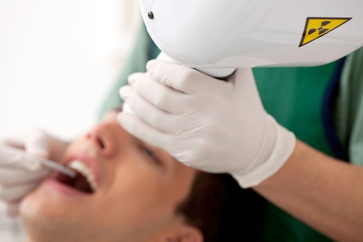 Detail of a dental x-ray machine, shallow depth of field with focus on x-ray head.