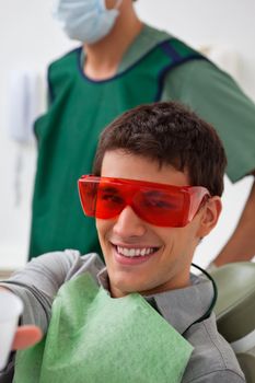 Portrait of patient at dental clinic with dentist standing in background