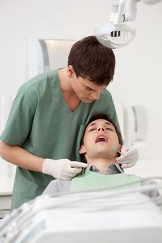 young man at a dentist apointment having his teeth checked