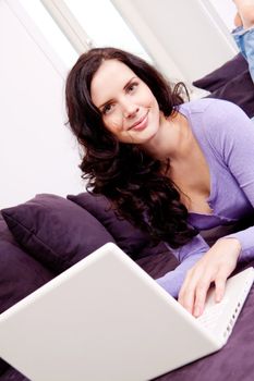 attractive young smiling woman on couch with notebook 