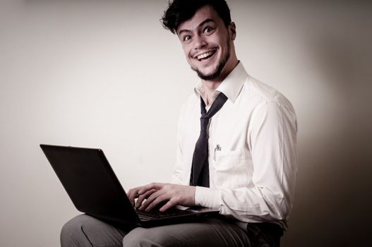 funny businessman using notebook on gray background