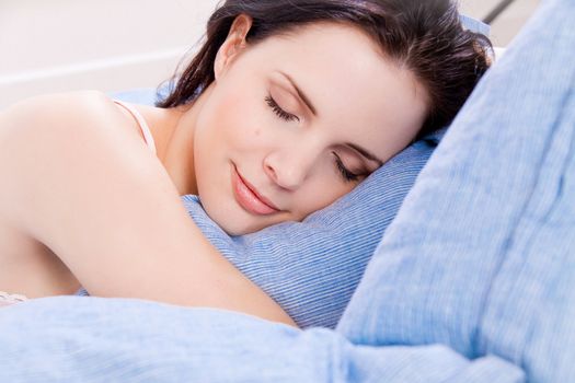 beautiful young woman sleeping in bed blue blanket 