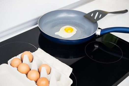 Fried egg in a frying pan on induction stove