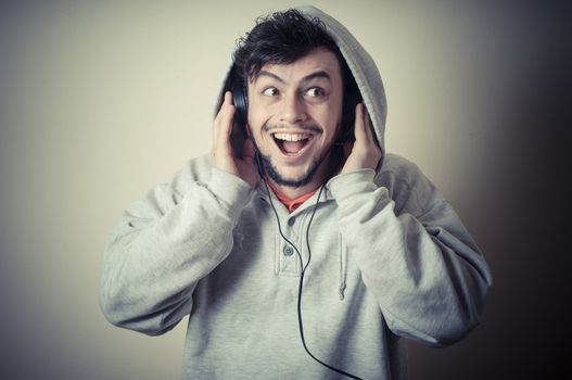 boy with sweatshirt and headphones on gray background 