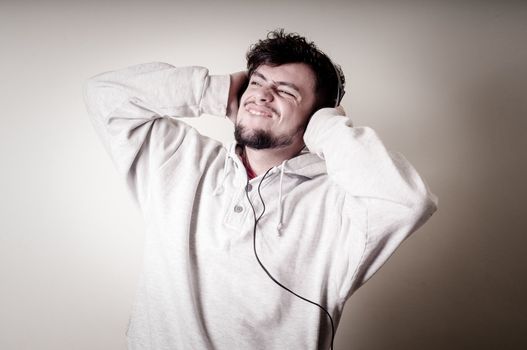 boy with sweatshirt and headphones on gray background 