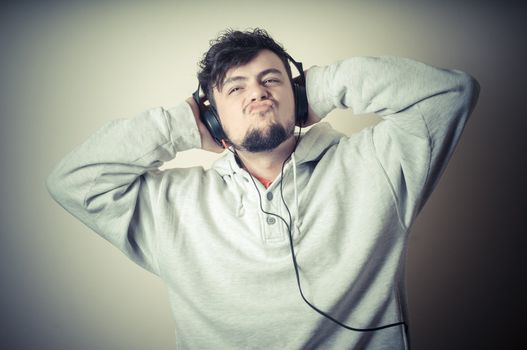 boy with sweatshirt and headphones on gray background 