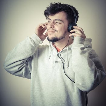 boy with sweatshirt and headphones on gray background 