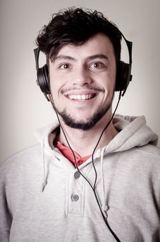 boy with sweatshirt and headphones on gray background 