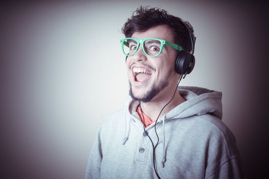 boy with sweatshirt and headphones on gray background 