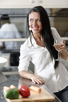 Beautiful young woman preparing the ingredients for a meal in her kitchen.