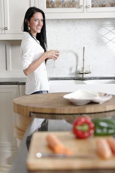 Beautiful young woman preparing the ingredients for a meal in her kitchen.