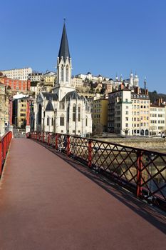 Lyon with red footbridge on Saone river and church 