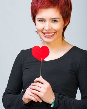 smiling young woman with a red paper heart