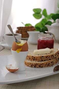 Soft-boiled egg with slices of oatmeal bread with butter for breakfast