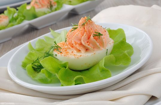 Eggs stuffed with pate salmon with red pepper in lettuce leaves