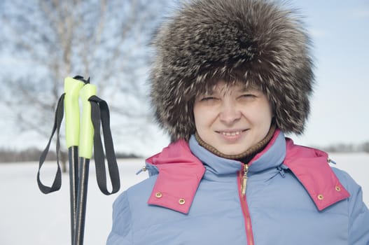 Woman tourist skier in snowy forest with ski poles