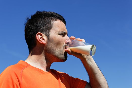 handsome man drinking water in blue sky 