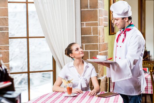 Chef brings a dish pretty woman in a restaurant, a pleasant time forwarding