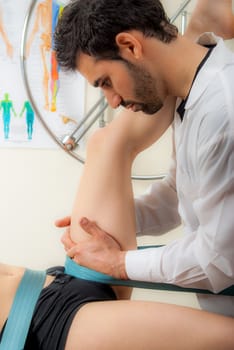 Manual, physio and kinesio therapy techniques performed by a male physiotherapist on a training plastic spine and a female patient