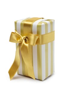 Gift box in gold duo tone with golden satin ribbon and bow isolated over white background.