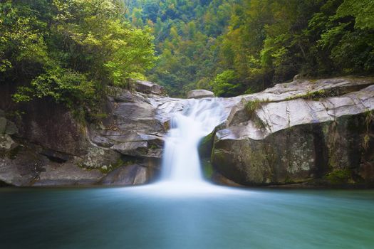 Deep forest waterfall in Wuyuan, China.