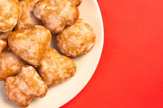 Polish ginger cookies on a plate on red background