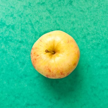 An apple on a vibrant green background