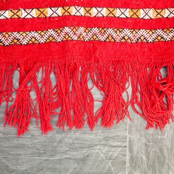 Edge of a bright red kilim rug on the floor