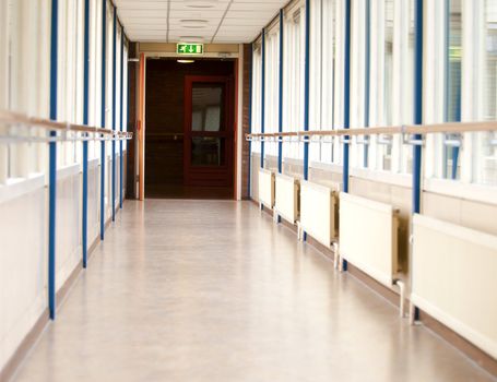 long empty corridor with an emergency exit sign