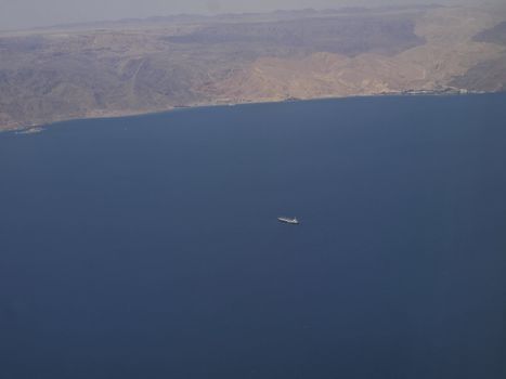 Aerial view of an oil tanker in the Red Sea desert with mountains in the background