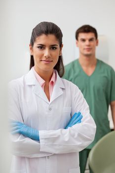 Portrait of confident female dentist with colleague standing in background