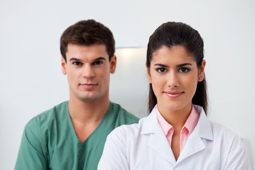 Portrait of female dentist standing with her assistant
