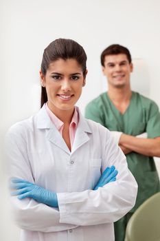 Portrait of pretty female dentist arms crossed with colleague standing behind