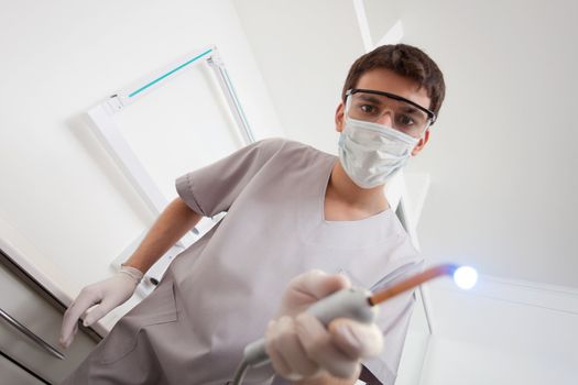 Dentist wearing mask holding medical equipment