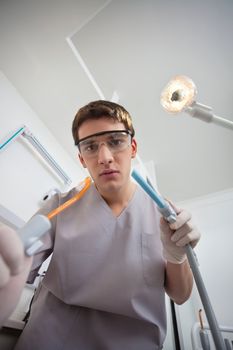 Portrait of male dentist holding dental tools