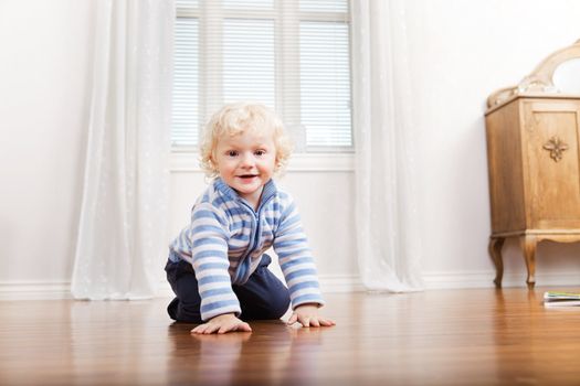 Portrait of happy cute child crawling on floor