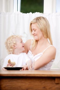 A mother and son laughing and having fun during a meal