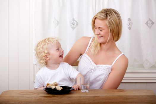 Mother a son laughing while eating lunch at a table