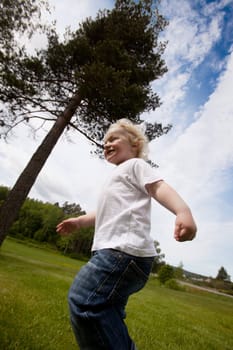 A young toddler boy running outside in a rural farm setting