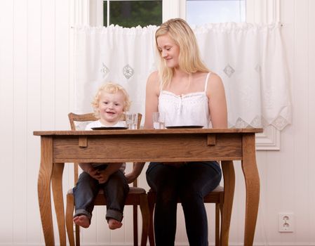 A happy smiling mother and child sitting at a table