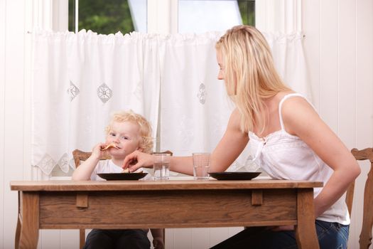 A mother and son eating lunch at a table