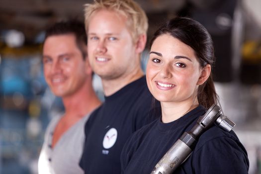 Portrait of a team of mechanics with a woman in the forground