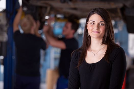 A happy female auto repair customer looking at the camera with a smile