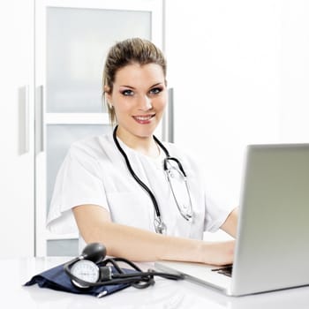 woman doctor in hospital with stethoscope and laptop