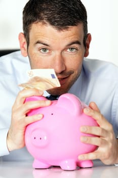 man with pink piggy bank and fifty euro banknote