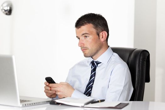 man in office with laptop sending a message 