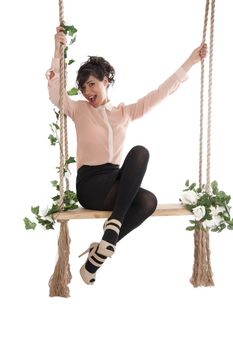 Emotional woman on a swing in the studio isolated background