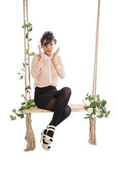 Emotional woman on a swing in the studio isolated background