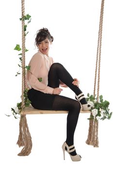Emotional woman on a swing in the studio isolated background