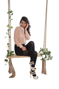Emotional woman on a swing in the studio isolated background